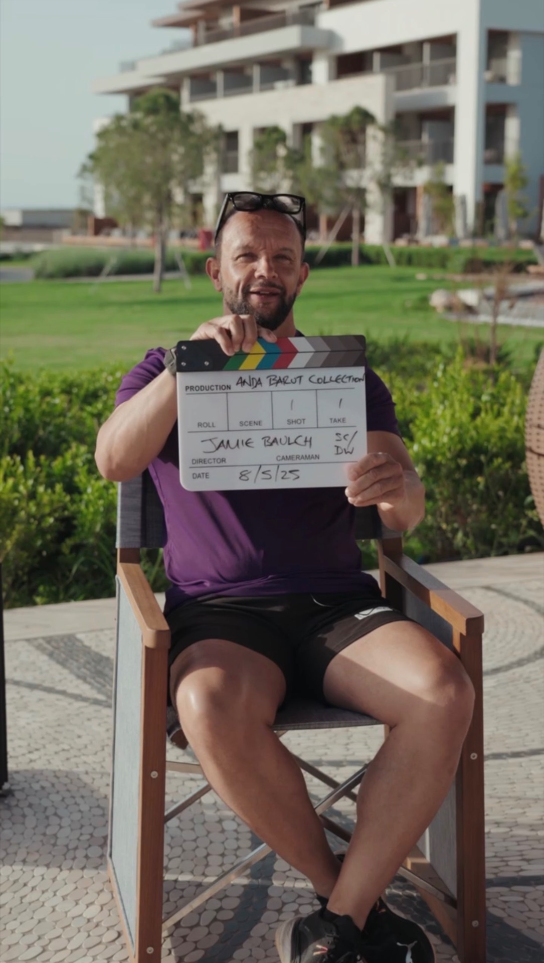 Jamie Baulch holding a film clapperboard on a brand shoot